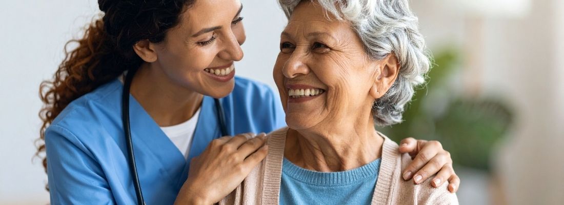 Lächelnde ältere Frau mit einer Pflegeperson